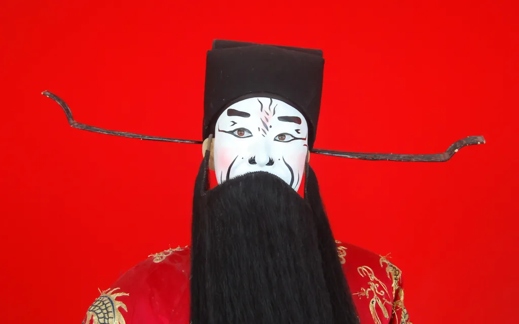 A Peking opera performer in the white-faced villain makeup and headdress of Cao Cao, photographed at the Mei Lanfang Grand Theatre in Beijing
