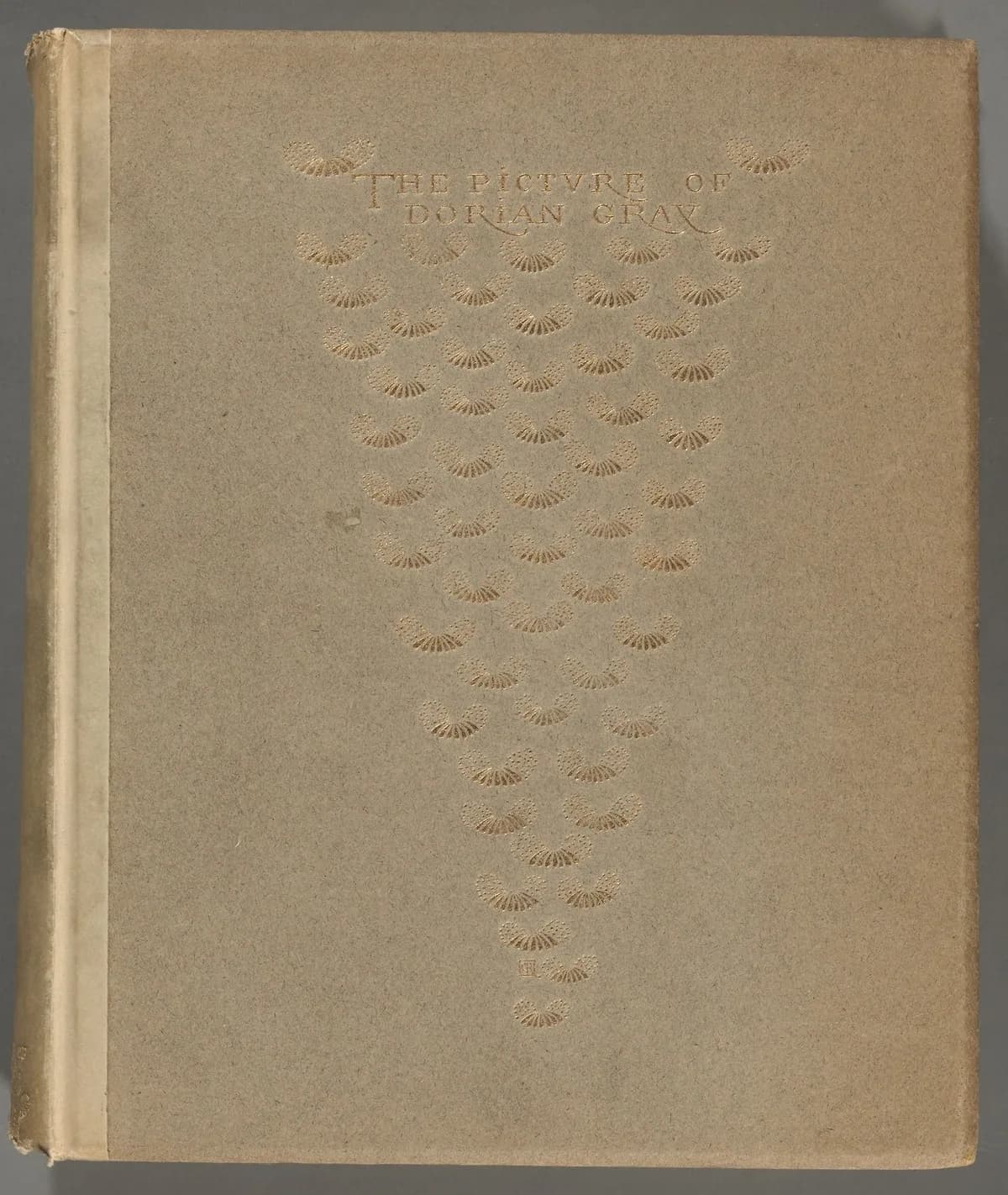 The 1891 first book edition of The Picture of Dorian Gray: a plain grey-brown cover with the title in gilt lettering above a tapering cascade of small gilt fan-shaped ornaments