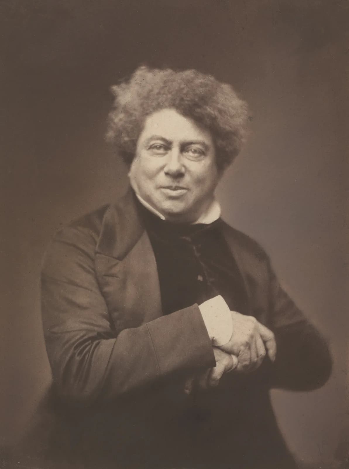 An 1855 photographic portrait by Nadar of Alexandre Dumas the elder, seated in a dark coat with his hair swept back, looking slightly away from the camera